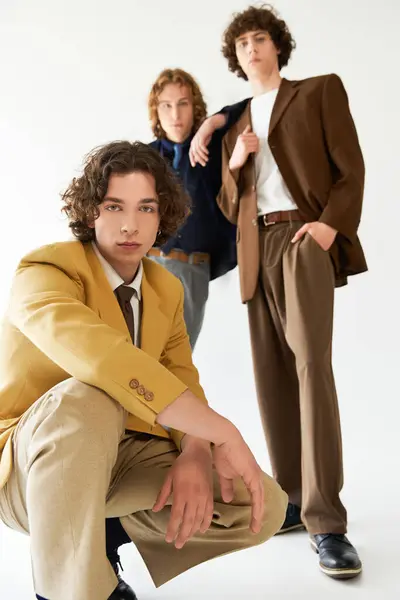 Three young friends are confidently posing in fashionable outfits, emphasizing their unique styles. — Stock Photo