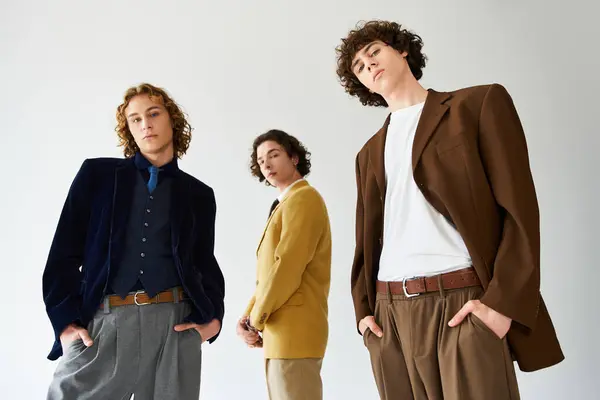 Three young men with distinct styles pose confidently in a stylish studio, exuding personality. — Stock Photo
