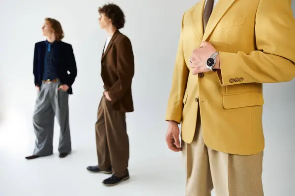 Trois jeunes hommes dégagent charme et confiance tout en posant dans une tenue élégante sur un fond propre. — Stock Photo