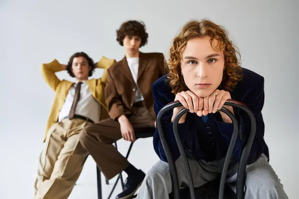 Three young men display their unique styles while posing confidently in a chic studio. — Stock Photo