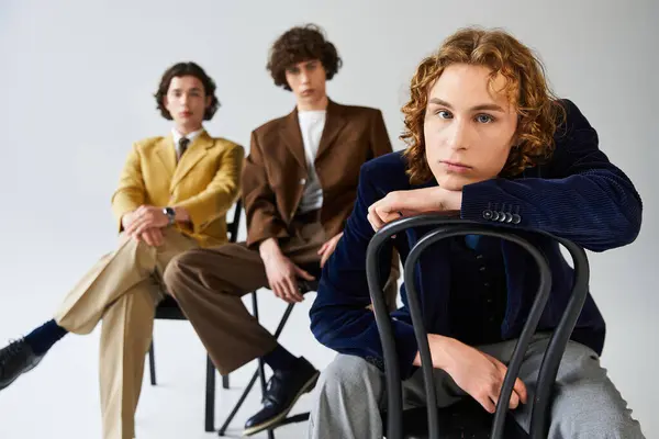 Three young men showcase their unique fashion styles while posing together in a studio. — Stock Photo