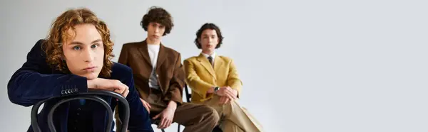 Three young men exude confidence and fashion while posing together in a modern space. — Stock Photo