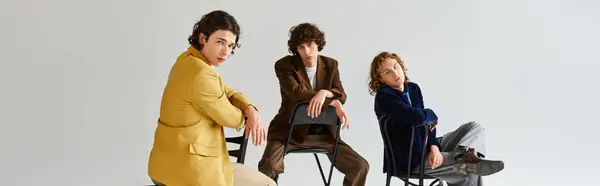 Three young friends express their unique styles while posing confidently in a stylish studio. — Stock Photo