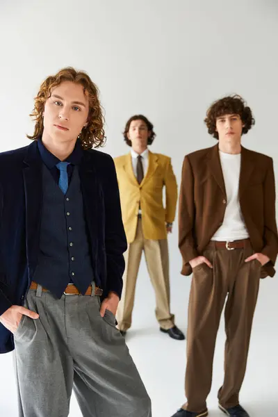 Tres jóvenes muestran con confianza sus estilos de moda únicos en un entorno de moda. — Stock Photo