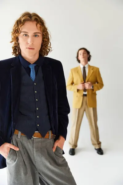 Two young men exude confidence and style while posing together in a vibrant studio setup — Stock Photo