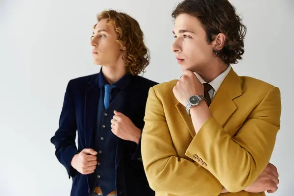 Two men in fashionable outfits pose confidently together, showcasing their unique styles. — Stock Photo
