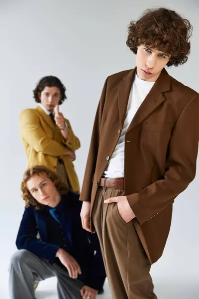 Trois hommes respirent la confiance et le style tout en posant ensemble, soulignant leurs tenues à la mode. — Photo de stock