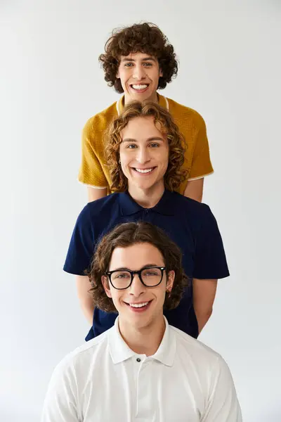 Three fashionable young men pose playfully, showcasing vibrant clothing and bright smiles. — Stock Photo