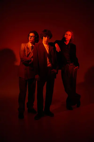 Three young men express their individuality through fashion in a vibrant atmosphere with warm tones. — Stock Photo