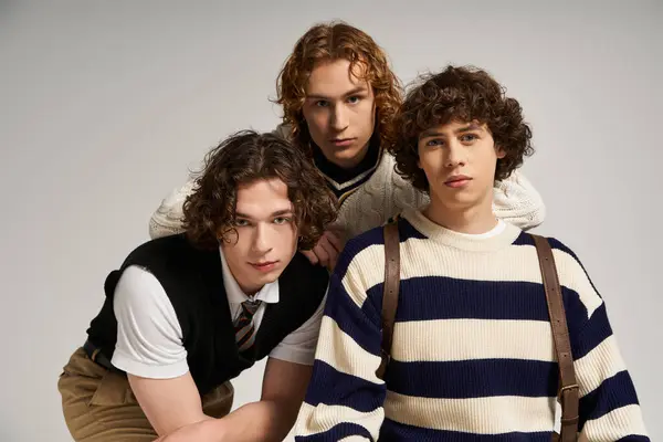 Trois jeunes hommes à la mode se réunissent, posant avec confiance et soulignant leurs styles uniques. — Stock Photo