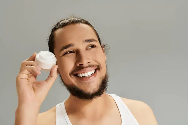 A handsome young bearded man enjoys a moment of joy, showcasing skincare as he smiles cheerfully. — Stock Photo