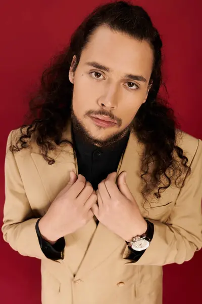 Young man with curly hair and beard presents a confident look while dressed elegantly. — Stock Photo