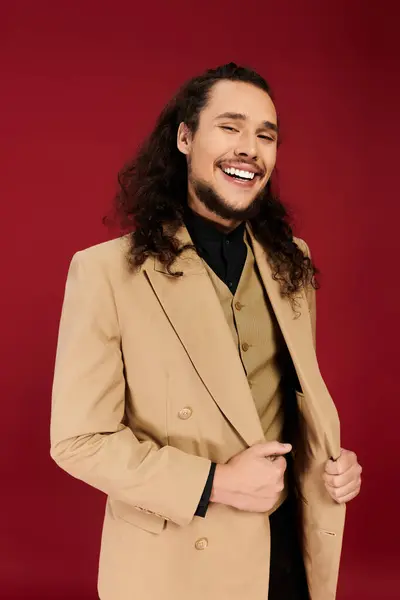 A charming young man with a beard showcases his warm smile while adjusting his stylish outfit. — Stock Photo