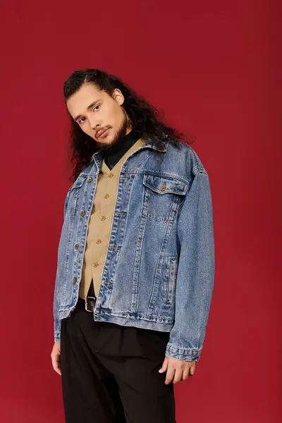 Handsome young man with a beard showcases stylish denim jacket and casual look on a bold background — Stock Photo