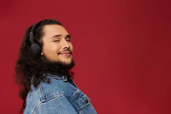 Un jeune homme élégant en tenue décontractée aime la musique, rayonnant de joie avec sa barbe. — Photo de stock