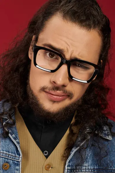Young man with a beard and glasses showcases his unique style while smirking playfully. — Stock Photo