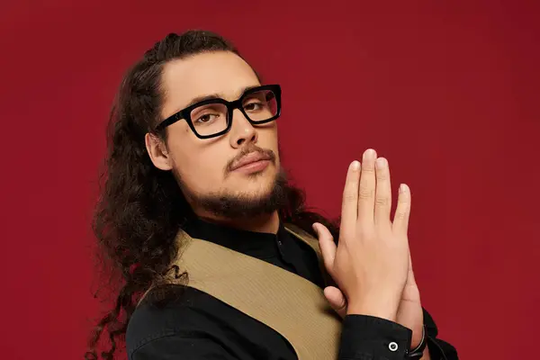 Confident young handsome man poses stylishly with hands together, showcasing charm and charisma. — Stock Photo
