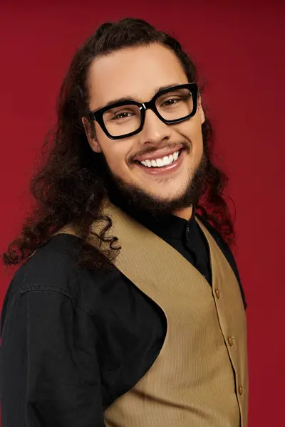 Young man with a beard and stylish glasses expresses joy while posing for a bright backdrop. — Stock Photo