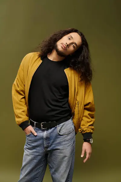 A handsome young man with a beard stands confidently in a casual outfit, showcasing his style. — Stock Photo