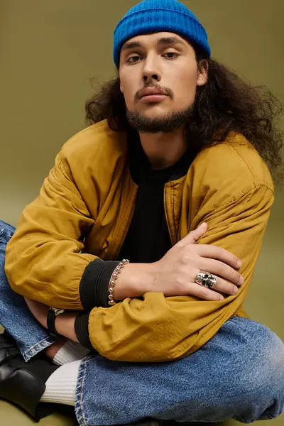 Handsome young bearded man displays a relaxed pose while dressed in trendy clothing and accessories. — Stock Photo