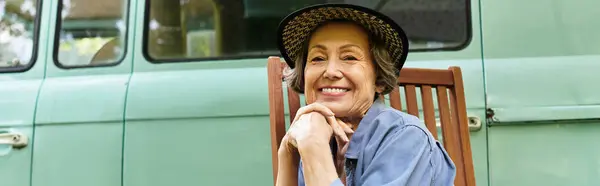 A joyful older woman relaxes in a sunny garden, surrounded by blooming flowers. — Stock Photo