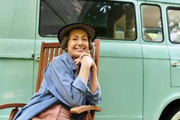 A joyful senior woman relaxes in her garden, surrounded by blooming flowers and lush greenery. — Stock Photo