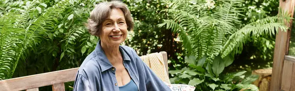 A senior woman relaxes on a bench in a tranquil, vibrant garden. — Stock Photo