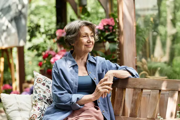 A senior woman relaxes on a bench, surrounded by vibrant flowers, reflecting her love for nature. — Stock Photo
