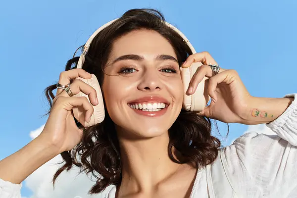 A young woman enjoys a blissful summer day outdoors, smiling radiantly under a clear blue sky. — Stock Photo