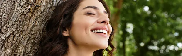 Wavy brown-haired woman smiles brightly while relaxing outdoors on a sunny summer day, banner — Stock Photo