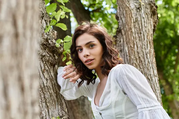 A young woman with wavy brown hair relaxes in the park, enjoying the summer sun. — Stock Photo