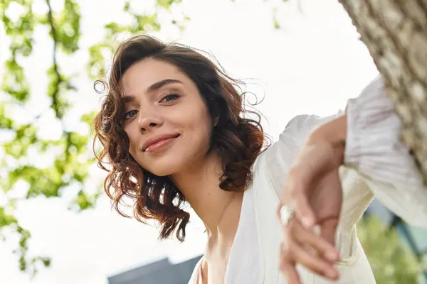 A pretty young woman enjoys a sunny day outdoors, surrounded by nature in a peaceful park. — Stock Photo