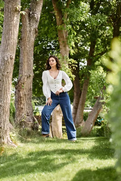 A graceful young woman with wavy brown hair enjoys the summer outdoors. — Stock Photo