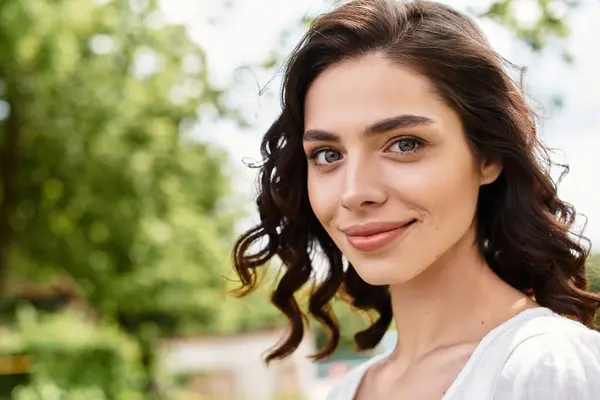 Smiling young woman enjoys a sunny summer day surrounded by greenery in a park. — Stock Photo