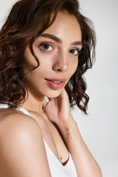 A confident young woman showcases her beauty with stunning makeup in a modern studio. — Stock Photo