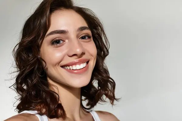 Bright and cheerful young woman showcases her artistry with lovely makeup in a cozy studio setting. — Stock Photo
