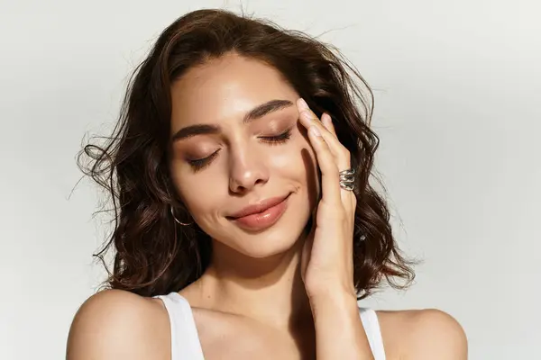 Young woman with beautiful makeup poses gracefully in a studio, exuding charm and confidence. — Stock Photo