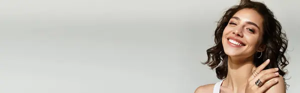 This young woman showcases her stunning makeup while posing in a grey studio, radiating beauty, banner — Stock Photo