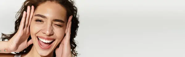A joyful woman with lovely makeup poses in a studio, radiating youth and confidence, banner — Stock Photo