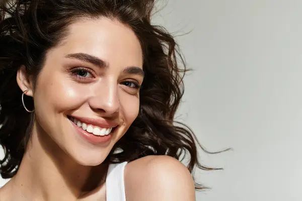 A young woman with pretty makeup poses confidently, showcasing her radiant smile and beauty. — Stock Photo