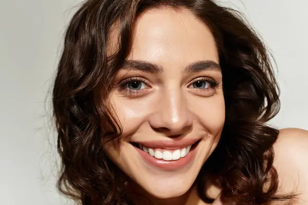 This stunning young woman showcases her beauty with expertly applied makeup while posing gracefully. — Stock Photo