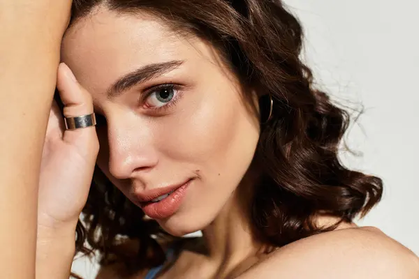 A young woman with beautiful makeup poses gracefully in a studio setting, highlighting her features. — Stock Photo
