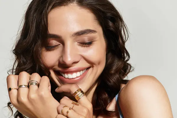 A beautiful young woman showcases her stunning makeup and joyful expression in a stylish studio. — Stock Photo