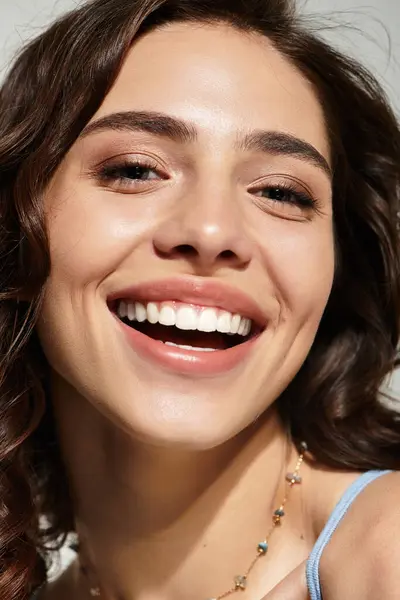 A young woman poses gracefully in a studio, showcasing her lovely makeup and bright smile. — Stock Photo