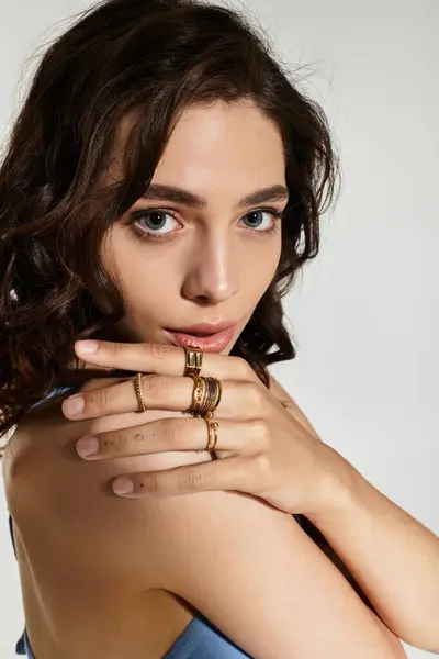 A young woman with beautiful makeup poses gracefully, highlighting her features and rings. — Stock Photo