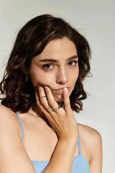 A beautiful young woman poses gracefully in a studio, showcasing her artistic makeup. — Stock Photo