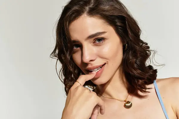 Young woman showcasing her flawless makeup while smiling and posing in a studio setting. — Stock Photo