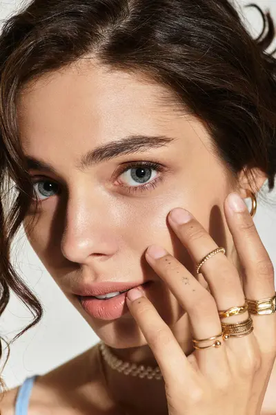 A young woman poses elegantly in a studio, showcasing her flawless makeup and features. — Stock Photo