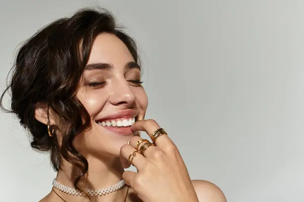 Young woman with beautiful makeup smiles brightly while showcasing elegant accessories. — Stock Photo