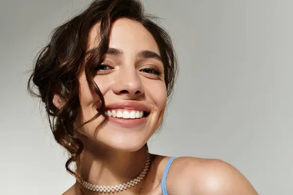 A young woman showcases her stunning makeup while playfully posing in a modern studio. — Stock Photo